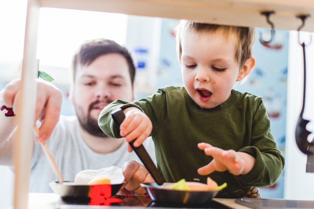 Foto eines Kindes beim Kochen an seiner Kinderküche.
